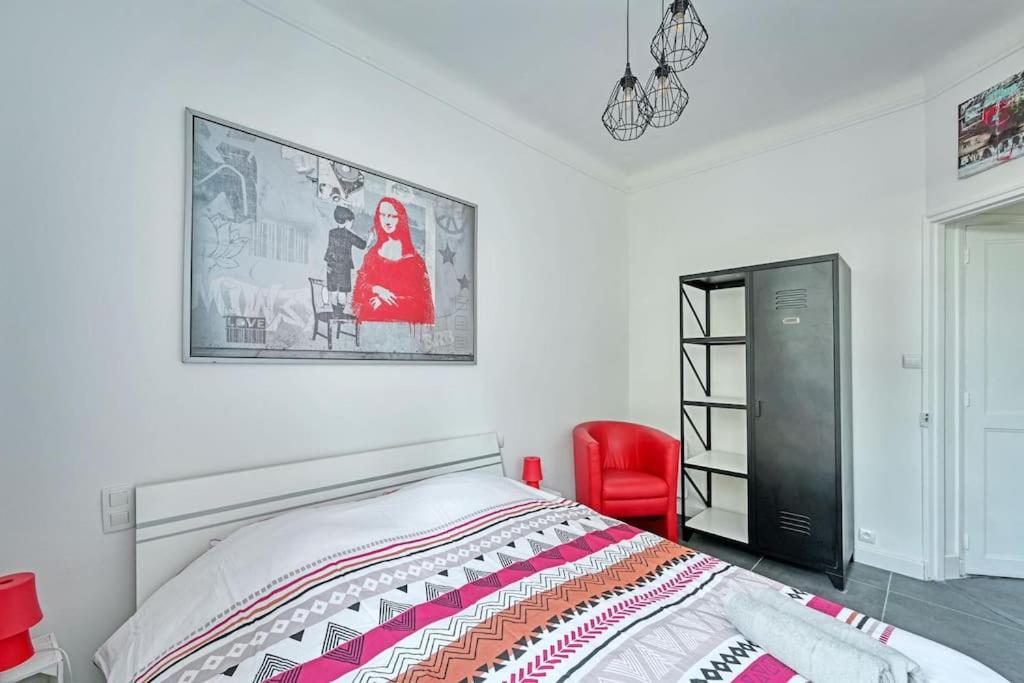 a bedroom with a bed and a red chair at The Rooftop - AC CLIM - Wi-Fi - Parking gratuit dans la rue in Avignon