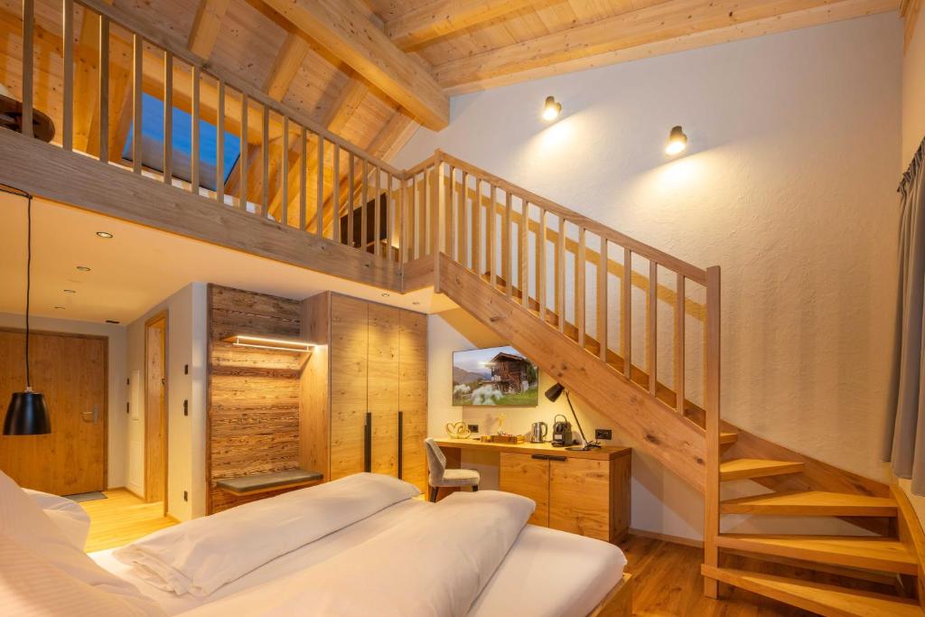 a bedroom with a loft bed and a staircase at Mountain Lodge in Grächen