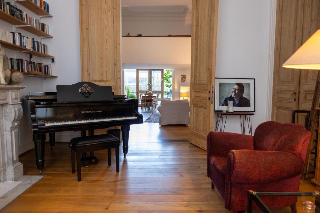 安特衛普的住宿－Heaven in Antwerp，客厅配有钢琴和椅子