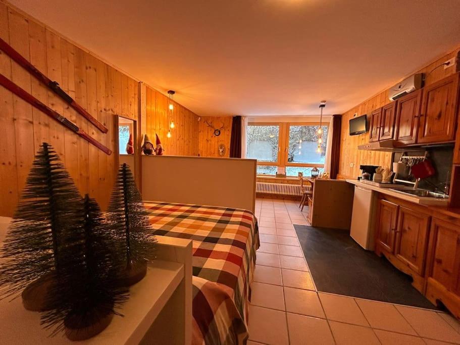 a kitchen and living room with two potted plants at La Baipa Accesso piste in Mezzana