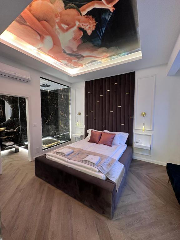 ein Schlafzimmer mit einem großen Bett und einem Gemälde an der Decke in der Unterkunft JACUZZI ROYAL SUITE in Budapest