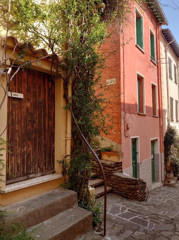 a house with a wooden door and stairs in front at 5COMA2 Appartement proche plage in Collioure