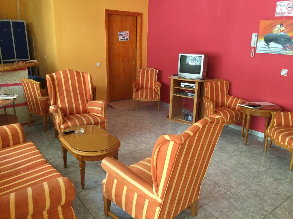 a waiting room with chairs and a tv at Tenerife Hostel in Los Cristianos