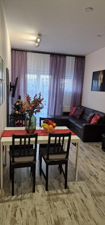 a living room with a table and chairs and a couch at Apartament Leopard in Bydgoszcz