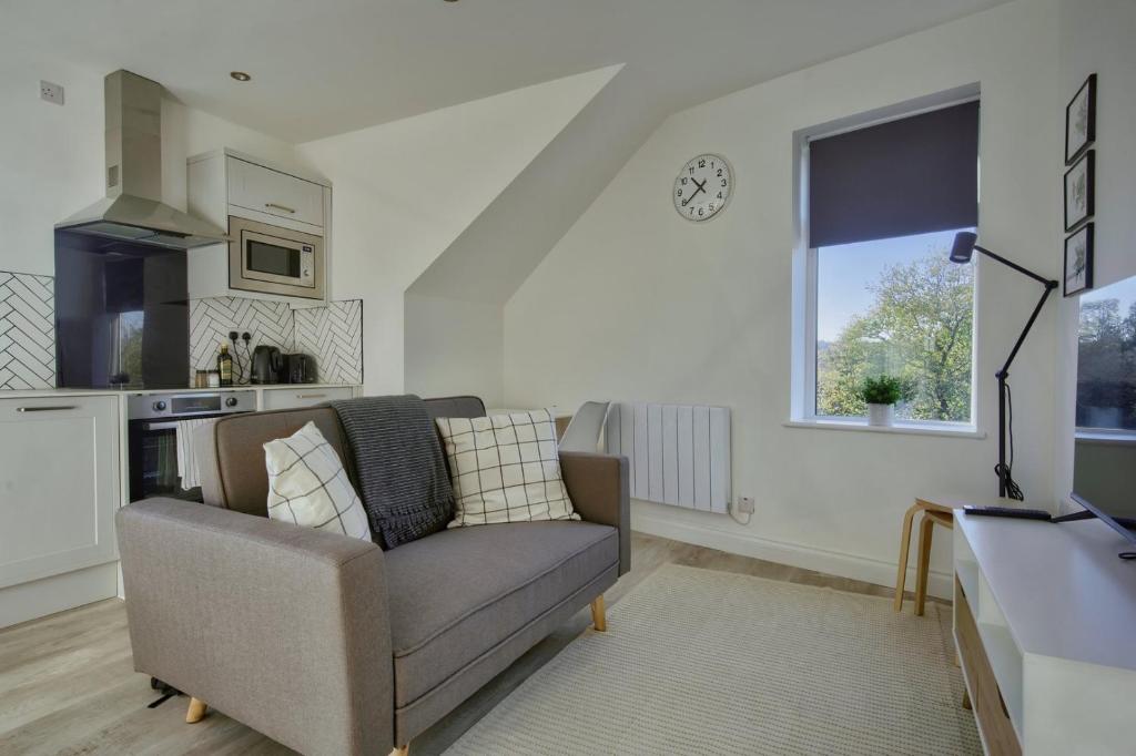 ein Wohnzimmer mit einem Sofa und einem Fenster in der Unterkunft GuestReady - Comfortable Leeds City Apartment in Kirkstall