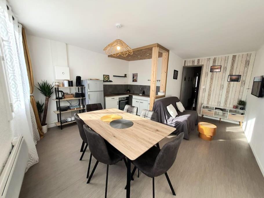 un salon avec une table et des chaises en bois dans l'établissement Appart village Gruissan : le flamant-rose, à Gruissan