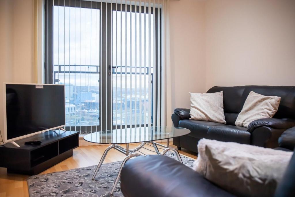a living room with a couch and a glass table at GuestReady - City Centre Apartment, Sleep 4 in Hunslet