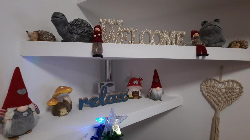 dos estanterías blancas con animales de peluche y adornos navideños en Bubu Apartament, en Petroşani