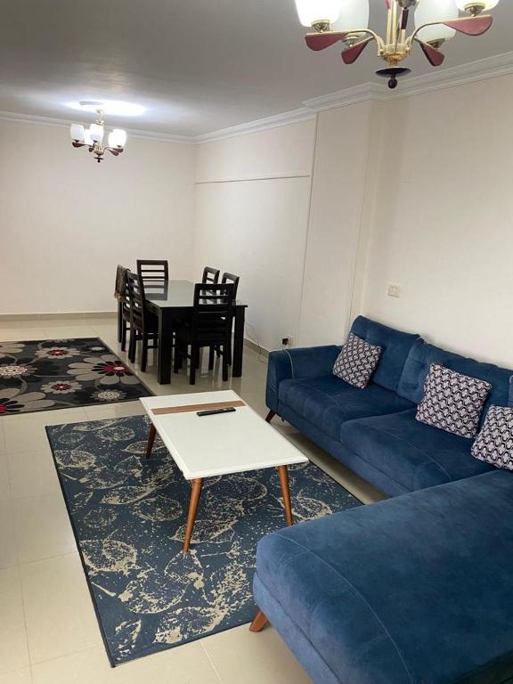 a living room with a blue couch and a table at City Square in Alexandria