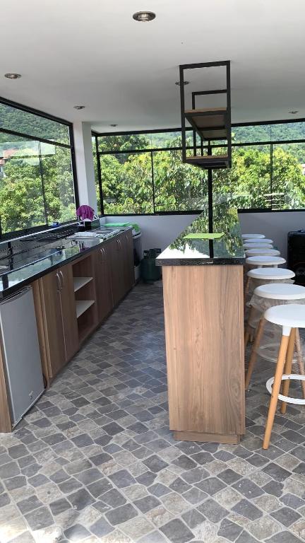 una cocina con encimeras y mesas y algunas ventanas en MILANO SUITE, en San Ramón