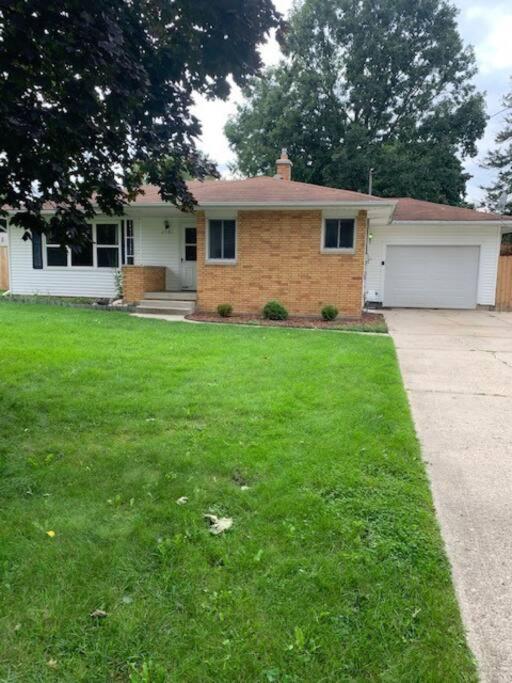 una casa con un prato e un vialetto di Perfect place quiet neighborhood, great for the family. a Saginaw