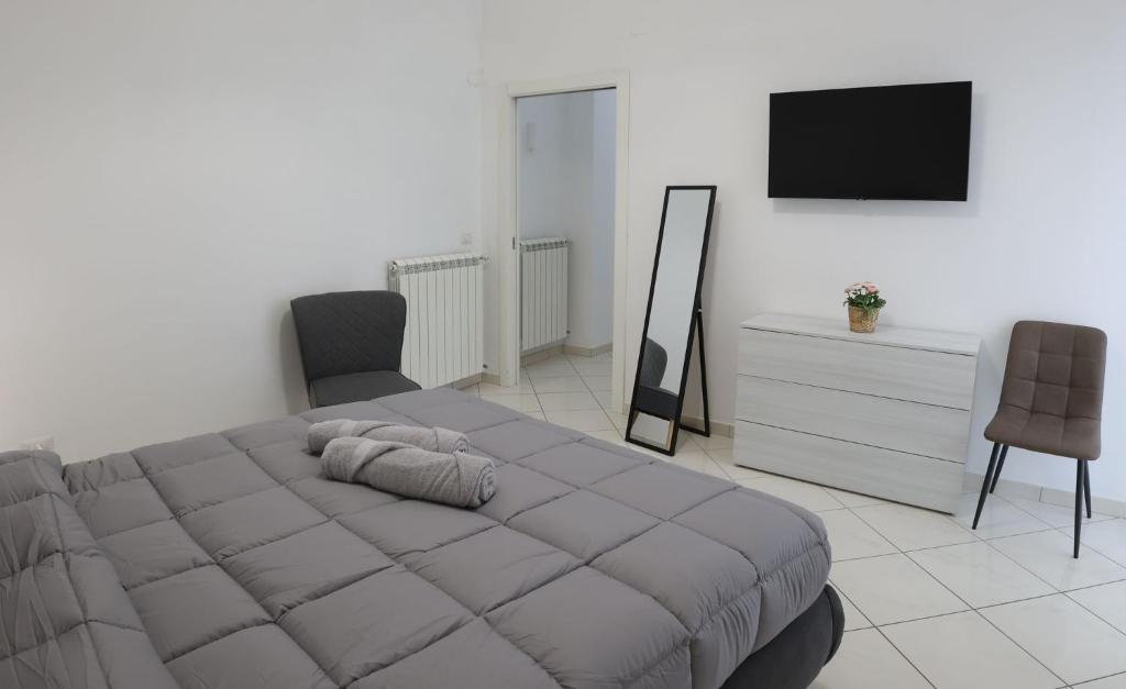 a bedroom with a bed and a tv and a chair at La casa dei nonni in San Giuseppe Vesuviano