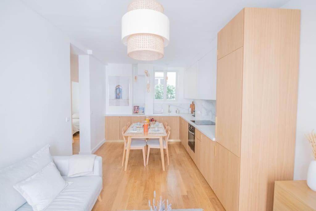 a white kitchen with a table and a white couch at *Cozy flat-Latin Quarter in the heart of Paris* in Paris