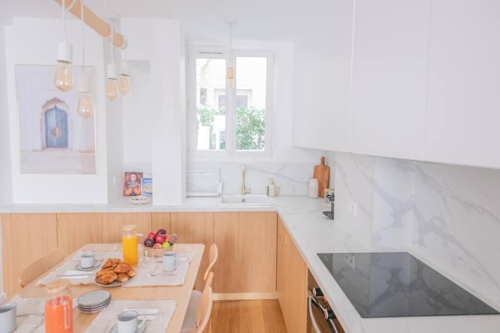 a white kitchen with a table with food on it at *Cozy flat-Latin Quarter in the heart of Paris* in Paris