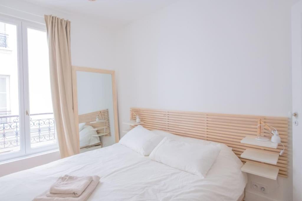 a bedroom with a white bed and a window at *Cozy flat-Latin Quarter in the heart of Paris* in Paris