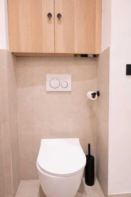 a bathroom with a white toilet and wooden cabinets at *Cozy flat-Latin Quarter in the heart of Paris* in Paris