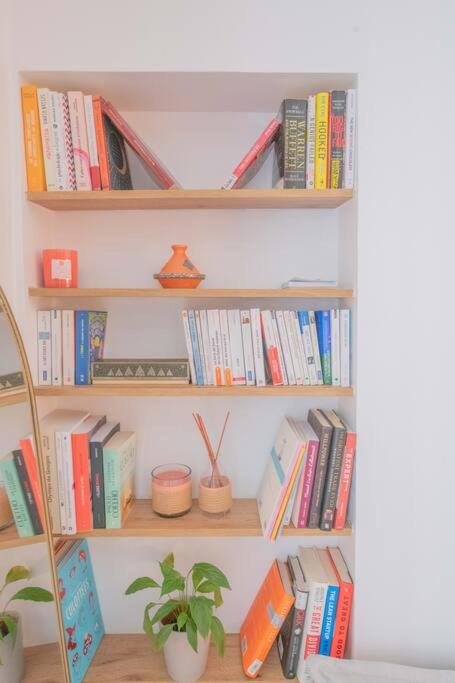 a book shelf filled with books and a potted plant at *Cozy flat-Latin Quarter in the heart of Paris* in Paris
