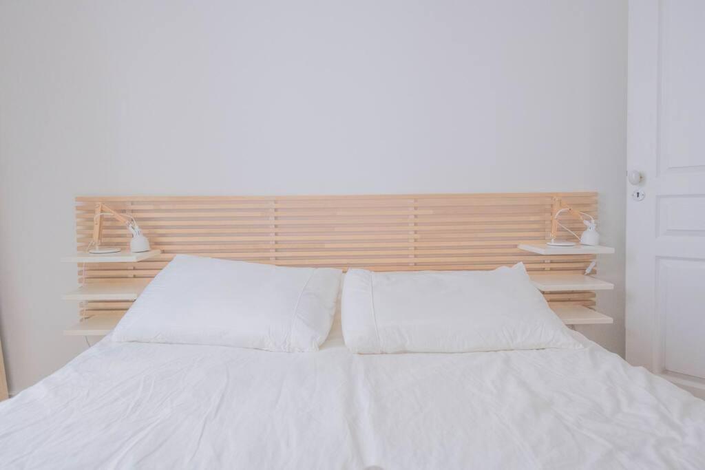 a white bed with white pillows in a bedroom at *Cozy flat-Latin Quarter in the heart of Paris* in Paris