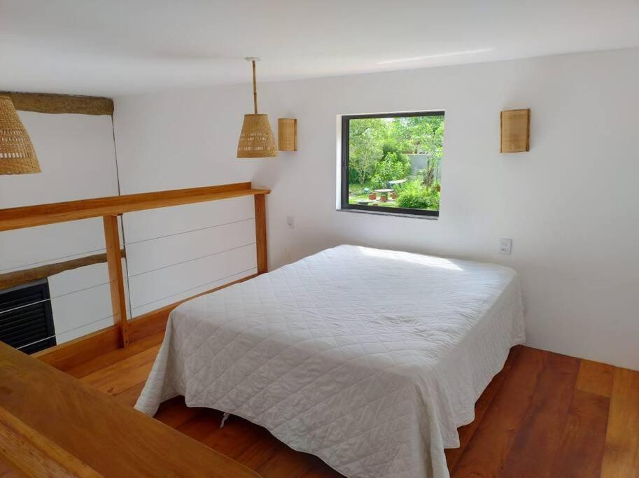 Un pat sau paturi într-o cameră la Loft praia e natureza juntos