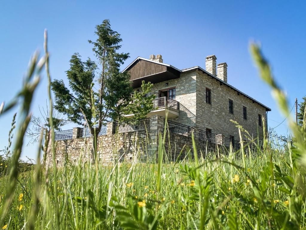 una vieja casa de piedra en un campo de hierba en Villa Arcturia, en Nymfaio