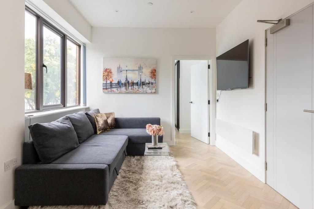een woonkamer met een bank en een tv bij Gorgeous, Modern apartment-fantastic location in Slough