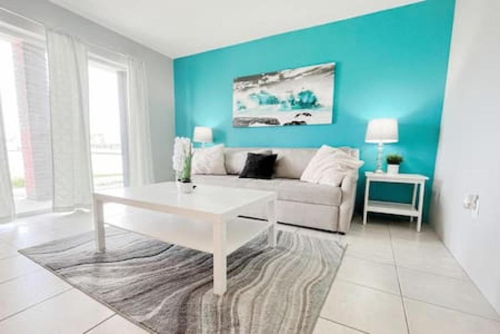 een woonkamer met een bank en een tafel bij Charming Beach Condo located in Amazing Location! in St Pete Beach