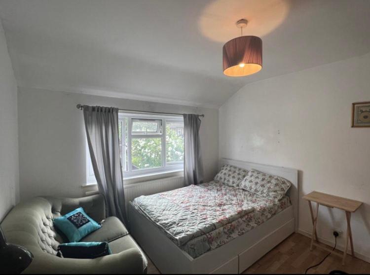 1 dormitorio con cama, sofá y ventana en Spacious Large Modern Double close to Central London Breakfast Included en Londres