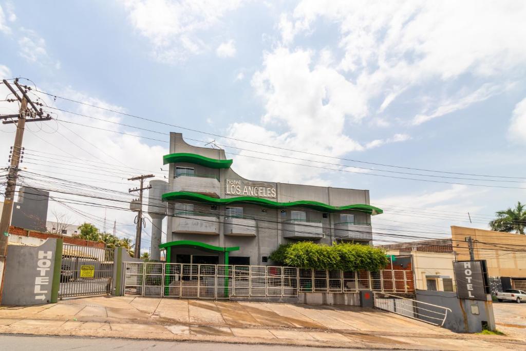 un bâtiment avec une clôture devant lui dans l'établissement Hotel Los Angeles, à Cuiabá