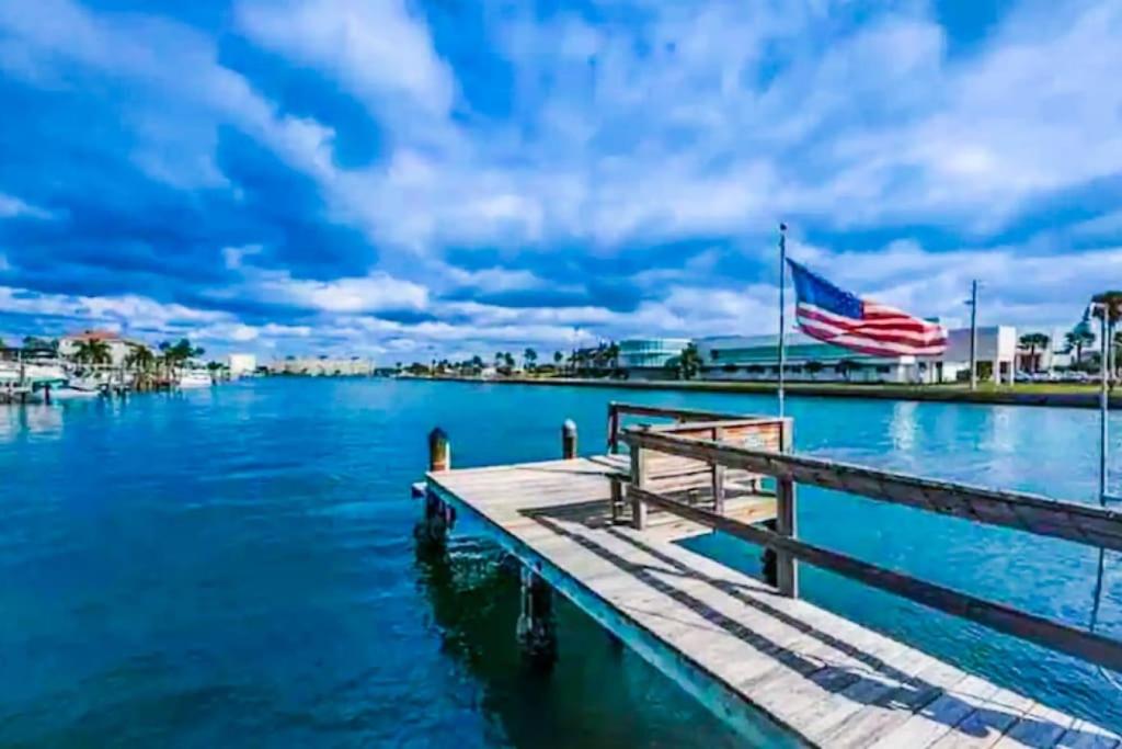 a dock on the water with an american flag at Beautiful 2 Bed Beach Condo With DOCK - Walk Everywhere! in St. Pete Beach