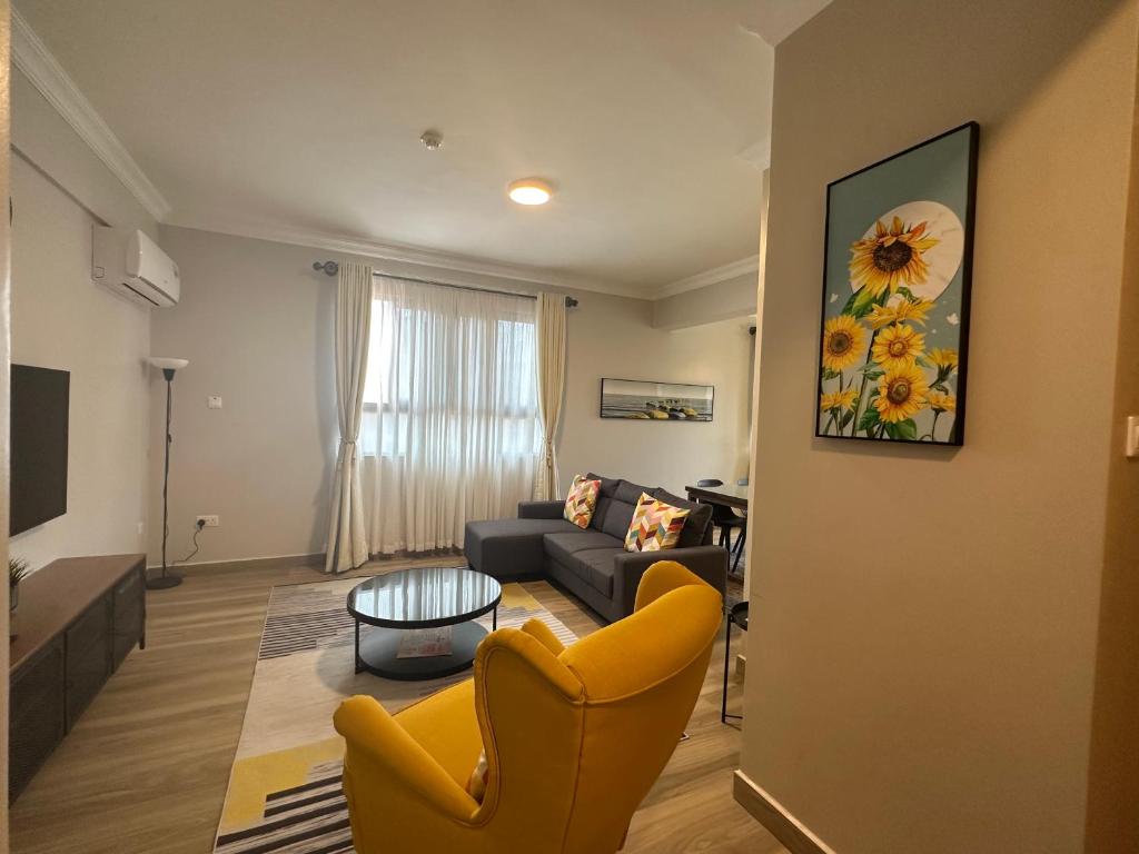 a living room with yellow chairs and a couch at Westwood Residences in Arusha
