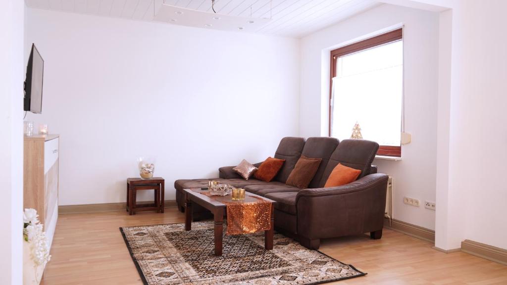 a living room with a brown couch and a table at Ruhige Monteurunterkunft in Oldenburg - Nähe Klinikum & Märkte in Oldenburg