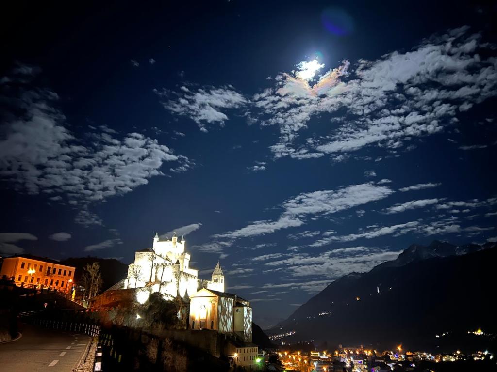 Una ciudad de noche con la luna en el cielo en casa del sole, en Saint-Pierre