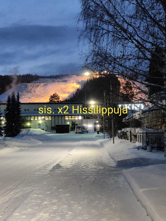 une rue enneigée avec un panneau indiquant syss x histiopula dans l'établissement Nilsiä city, Tahko lähellä, 80 m2, include x 2 Ski Pass, à Tahkovuori