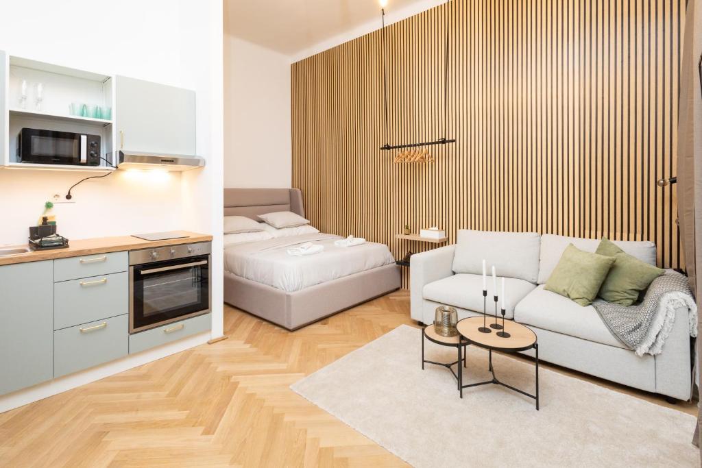 a living room with a white couch and a kitchen at Charming retreat near town centre in Vienna