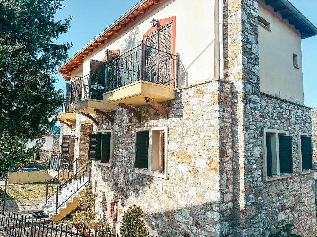 a stone house with a balcony on the side of it at Filimon GuestHouse Villa in Xanthi