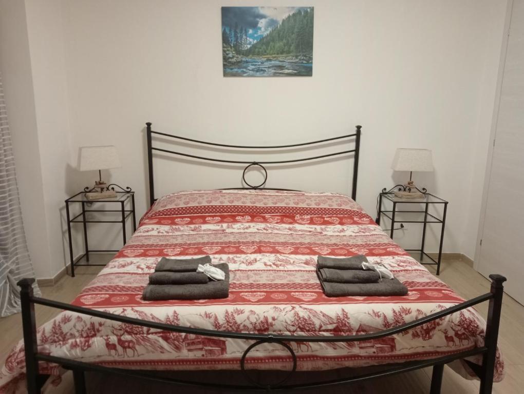 a bedroom with a bed with a red blanket and two lamps at Maison Loren Pila in Cerise