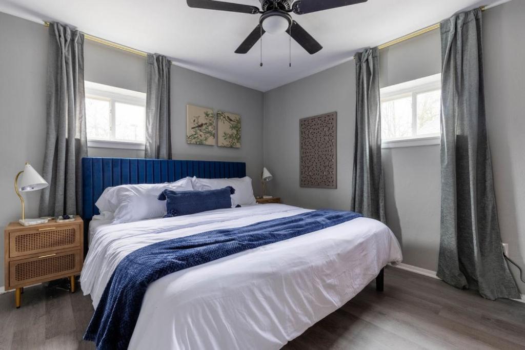 1 dormitorio con 1 cama con cabecero azul y ventilador de techo en Westlake Elegance - Detroit Unit 3, en Westlake