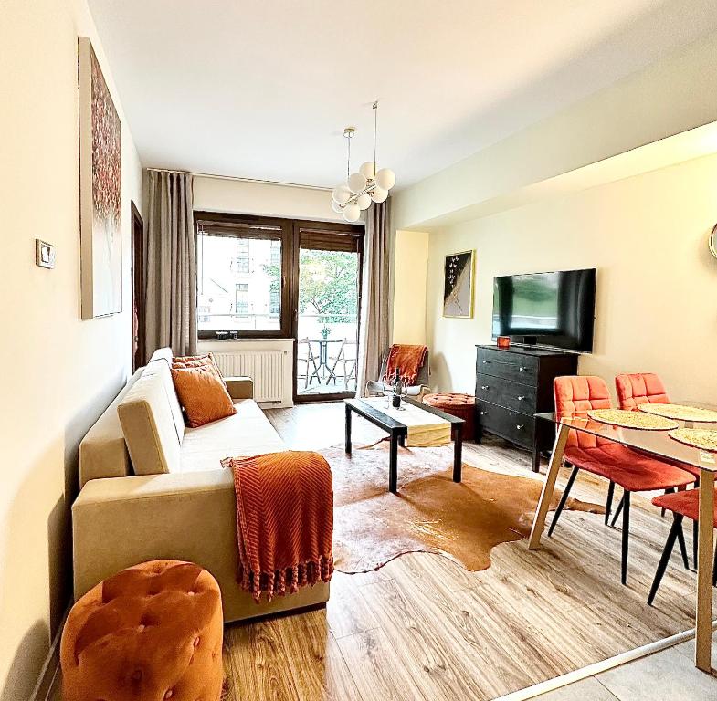 uma sala de estar com uma cama e uma mesa em Apartament przy Bulwarach em Krynica-Zdrój