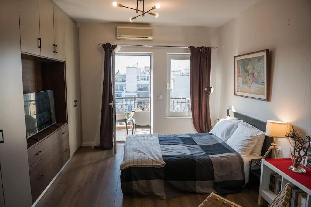a bedroom with a bed and a tv and a window at City Kiss in Orestiada