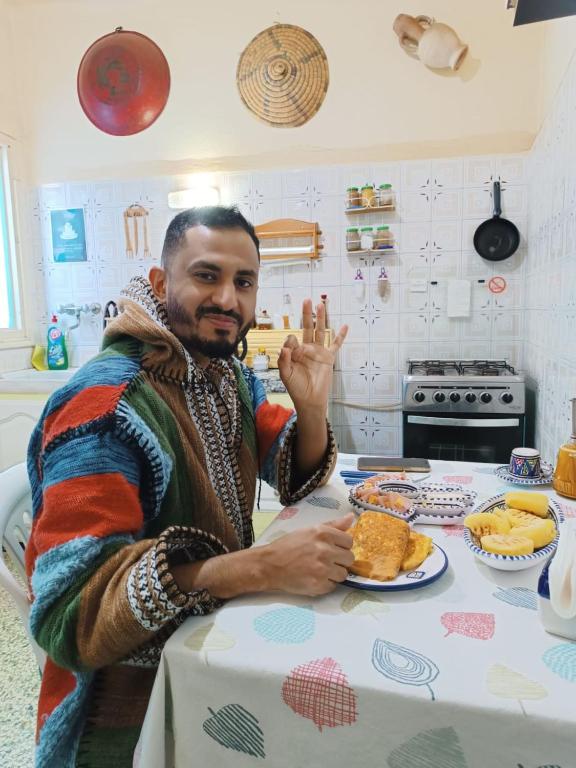a man sitting at a table with a plate of food at Dar Hkaïem in Sousse