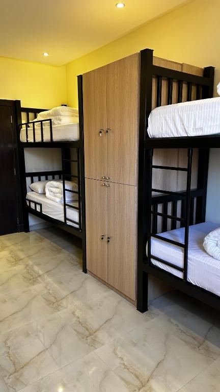 um quarto com três beliches num quarto em Urban Bunks - Riyadh em Riyadh