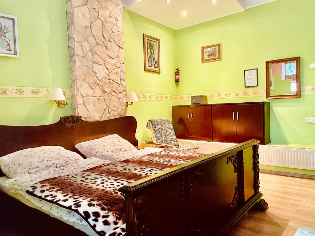 Bett in einem Zimmer mit grünen Wänden in der Unterkunft Sunny & Green in Hévíz