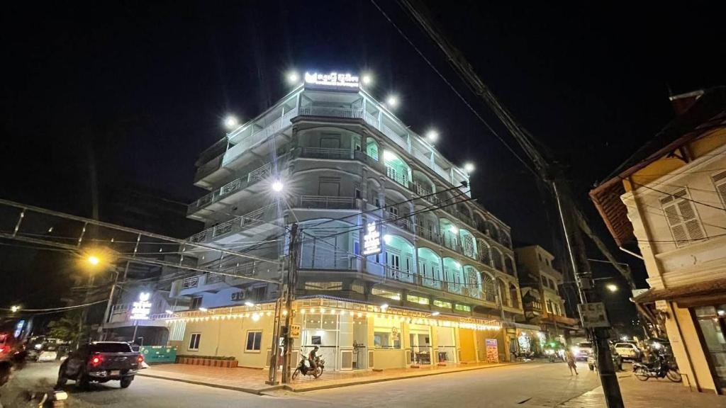 un edificio con un cartel encima por la noche en Suorsdei Boutique, en Kampot