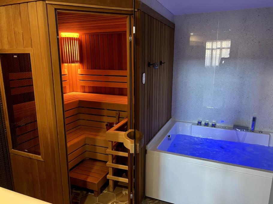 El Gallinero, Loft con sauna y jacuzzi في Casas Altas: حمام مع حوض أزرق كبير في الغرفة
