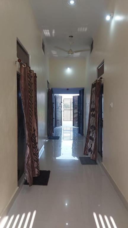 an empty hallway of a house with open doors at laxmihomestay in Khajurāho