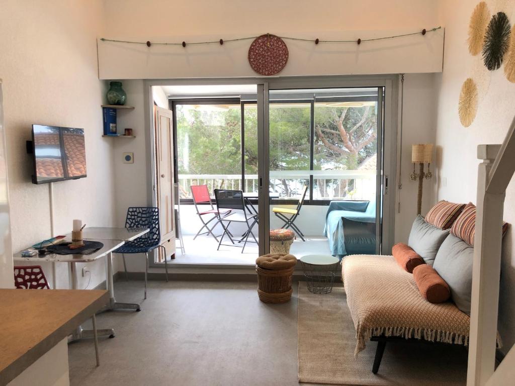 un salon avec un canapé et une table dans l'établissement Carro duplex les pieds dans l'eau et la tête dans les pins, à Martigues