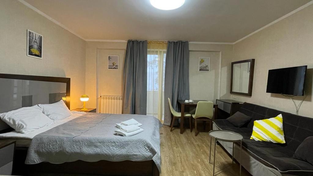 a hotel room with a bed and a couch at Orbi Palace Eleonora in Bakuriani