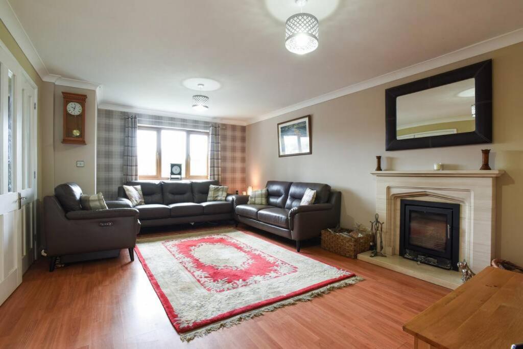 a living room with a couch and a fireplace at Large family home pool table in Waterlooville