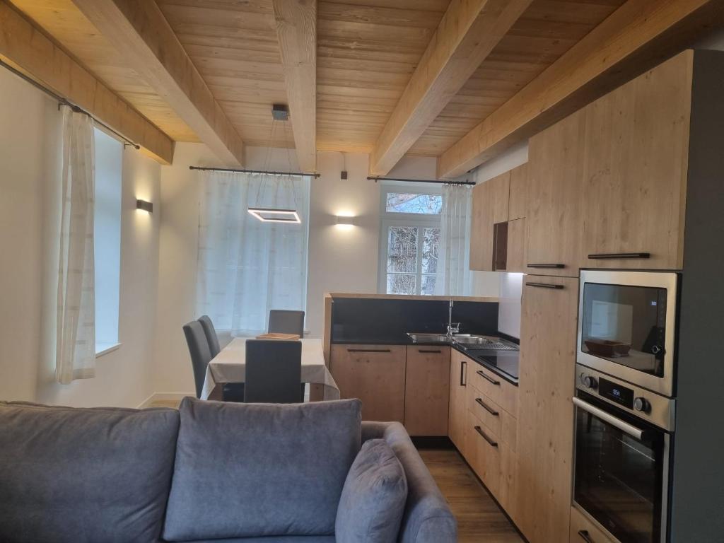 a living room with a couch and a table and a kitchen at Appartamento Vale e Schena Cortina 4 posti letto in San Vito di Cadore