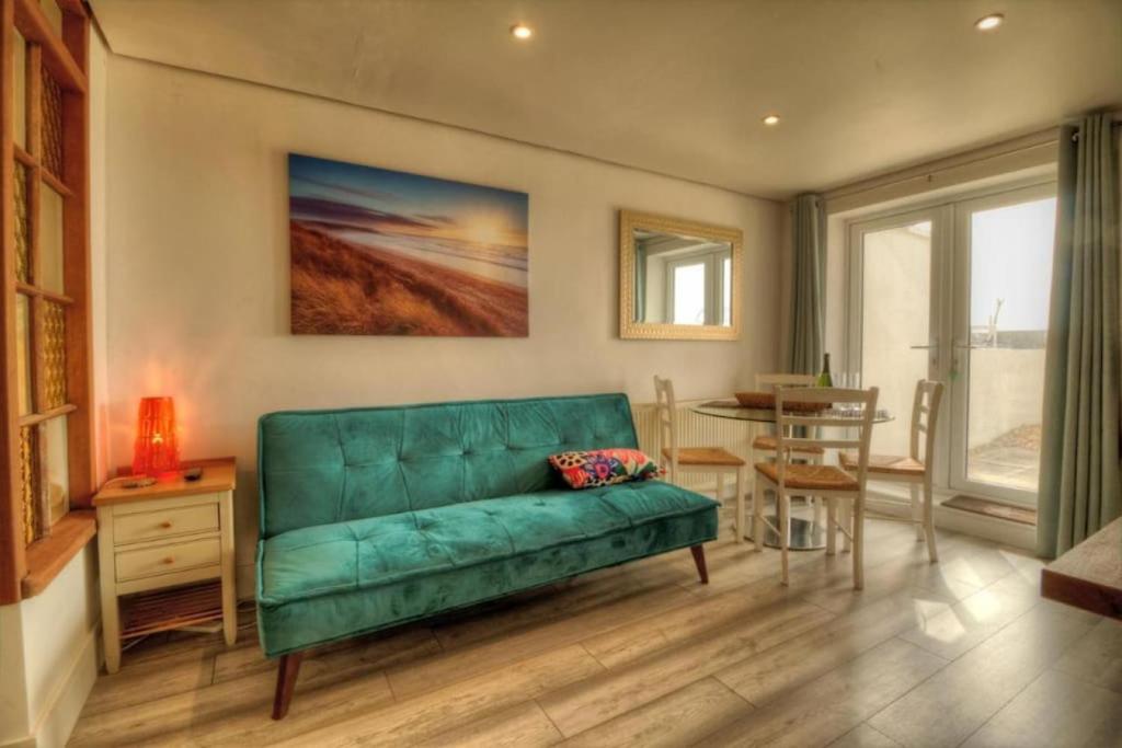 a living room with a green couch and a table at Stunning Solent View Beachfront Apartment, Sleeps4 in South Hayling